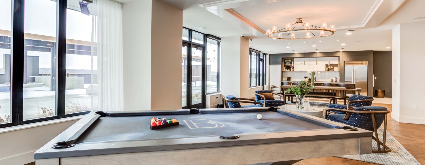 Large lounge area with multiple tables for seating and a full kitchen